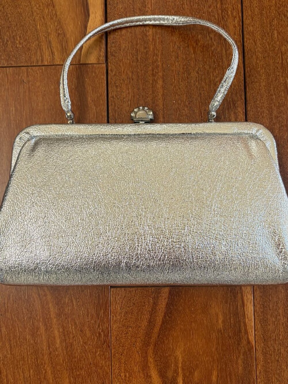 Silver vintage metallic evening clutch with a kiss lock closure and thin strap